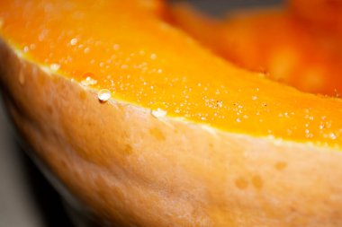 Balkabağından bir kesikte bir damla meyve suyu çıktı. Balkabağı diliminde meyve suyu. Bir damla meyve suyu. Kesilmiş bir balkabağına parlak damlalar..