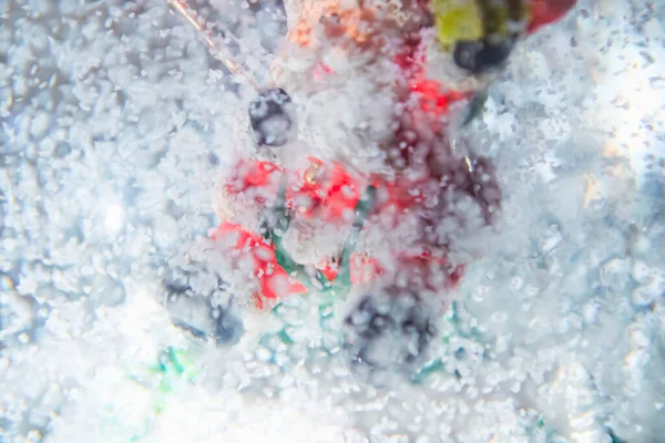 In the snow globe is Santa Claus. Snow falls in the globe. A snow toy. The focus is blurred because of the snow.