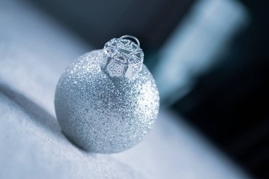 Soyut bir arka planda, Noel ağacında parlak bir top. Karanlık bir arka planda parlak bir Noel topu. Noel ağacında mavi-gri tonlarda bir top.