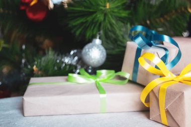 Renkli kurdeleli paketlenmiş hediyeler Noel ağacının altında yatıyor. Ağacın altındaki hediyeler.