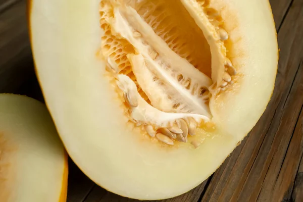 A young melon close-up. Cut melon with seeds. Slicing melon, peeling from grains.