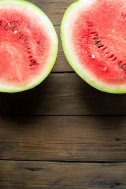 A cut watermelon. A large watermelon is cut into two halves. Watermelon on a wooden table..