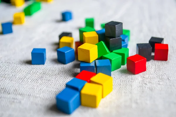 Colored cubes on gray cloth. Not a table scattered with children's cubes. Colored children's cubes on the floor. .