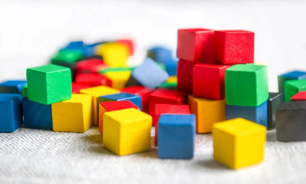 Not a table scattered with children's cubes. Colored cubes on gray cloth. Colored children's cubes on the floor. .