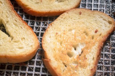Kızartma tavasında tost. Kızartma tavasında sıcak tost pişirmek. Tahıllı fotoğraf. Kızartma tavasında tahıllı kızarmış ekmekli retrofoto..