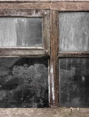 Old window with wooden frame and dirty glass. There is a window with a wooden frame in the landfill. A broken window. window for restoration with old glass and wooden frame.