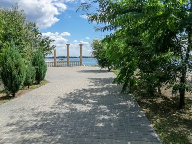 Tourism next to beautiful antique columns. The trail leads to ancient ruins. Antique columns on the seashore.