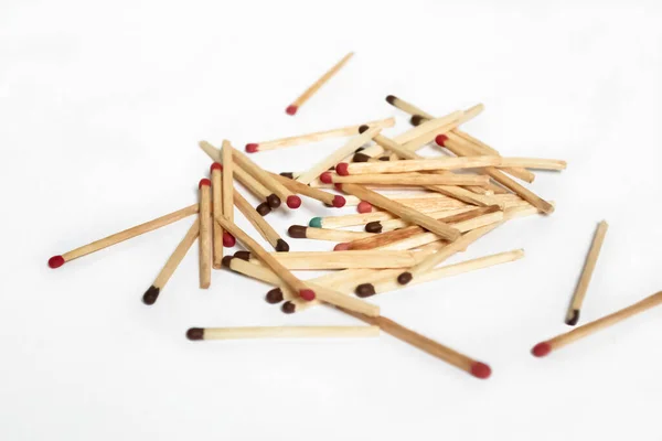 Lots of matches on a white background. an exception to the mass is a match with a different color. Among the matches, one blue one stands out. Matches with different colors on the heads.
