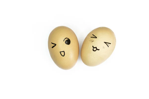 两个黄色的蛋 白色背景上有彩绘的情感符号 有微笑的蛋 眼睛盯着白色 有脸的蛋鸡蛋上的微笑 — 图库照片