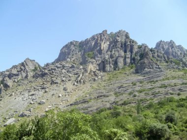 Manzara dağlık bir alandır. Dağ manzarası. Yeşil ağaçları ve güzel gökyüzü olan yüksek dağlar. Dağlardaki doğanın güzelliği.