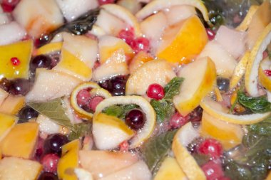 Meyve, böğürtlen ve yeşil yapraklardan komposto hazırlama. Kullanışlı komposto. Frenk üzümü, elma ve nane yaprakları kompostoda.