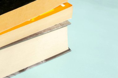 Mavi arka planda bir yığın kitap yatıyor. Açık mavi arka planda güzel kitaplar. Eğitim materyali için hafif arkaplan.