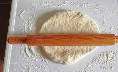 Testte raptiye var. Hamuru pizzanın üzerine dök. Pişirme - hamur hazırlığı. Mangıra istenen şekli veriyorum..