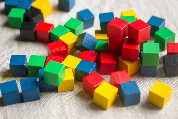 Colored cubes on the fabric. On the table there are many colored cubes for the game. Bright children's cubes. children's cubes made of wood.