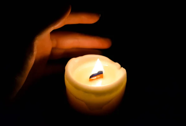 Στο Σκοτάδι Ένα Χέρι Φτάνει Για Ένα Κερί Φλόγας Ζεστασιά — Φωτογραφία Αρχείου