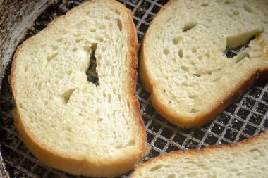 Tavada tost. Kızartma tavasında ızgara ekmek. Kızardıktan sonra altın hamurlu ekmek.