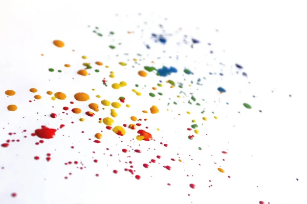 stock image Splashes of paint on a white background. There are many drops of colored paint on white paper. Colored spots of paint on a white background.