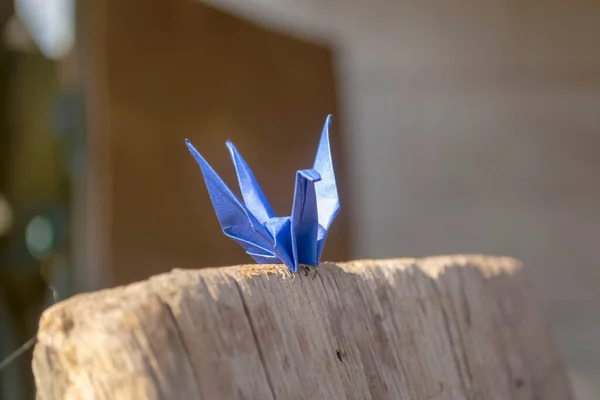 Blue paper crane on a wooden board. Beautiful paper crane. Fulfillment of desires - paper crane, Japanese origami.