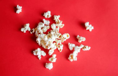 Kırmızı arka planda patlamış mısır. Film izlemek için patlamış mısır. Kırmızı arka planda beyaz patlamış mısır. Film izlemek için atıştırmalıklar.