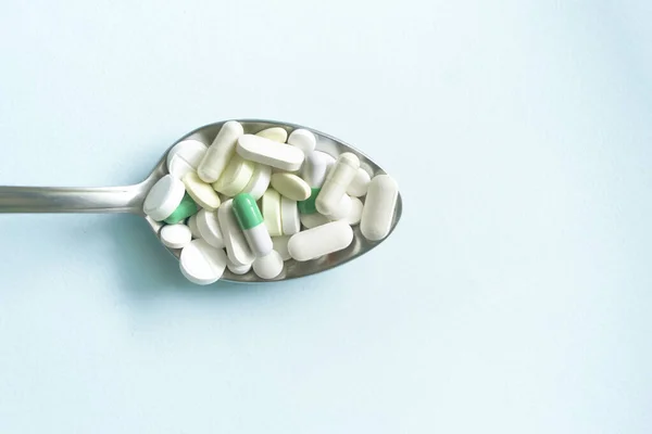 Sobre Fondo Azul Encuentra Una Cuchara Llena Tabletas Cápsulas Medicina — Foto de Stock