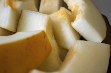 Kavun parçalara bölündü. Karanlık bir arka planda, hafif karpuz parçaları yakın çekimdir. Evde kavun dilimliyorum. Olgun. Parçalanmış sulu kavun.