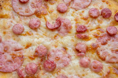 Salamlı pizza. Peynir ve sosise yakın kızarmış pizza. Sosis ve sosisli ve peynirli pizza..