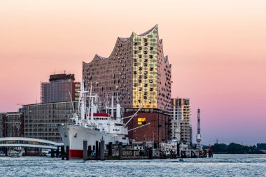Hamburg, Almanya - 09 06 2023: Elbphilharmonie 'nin suyundan ve akşam gökyüzü kıpkırmızı olan San Diego kaptanından görüş