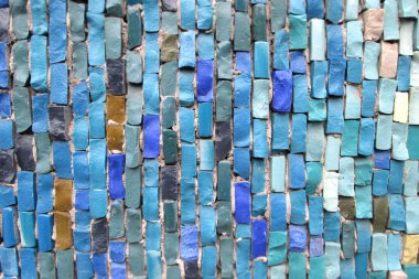 Farklı şekillerde taşlarla renklendirilmiş. Mavi, hardal, mozaikte açık yeşil renk. Yatay bileşimde taş elementlerin dikey düzenlenmesi. Modern teknik dekor.