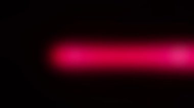 Siyah ekranda hareket eden bir kırmızı ışık. 4k bulanık lazer lambası. Kaplama için canlı stok efekti.