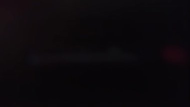 Siyah ekranda titreşimli lazer şeridi. Bulanık parıltı ve enerji kayboluyor. 4K 'da üst üste koymak için stok etkisi.