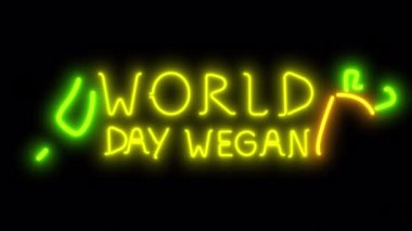 Siyah ekranda neon animasyon Dünya Vegan Günü. Sallanan bir havuç ve yeşil yapraklı stok videosu.