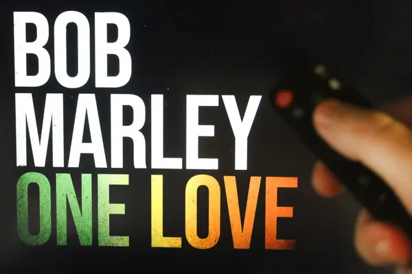 Seyirci Bob Marley One Love filmini elinde uzaktan kumandayla izliyor. Stok editör fotoğrafı. Ukrayna. Kiev. 04.14.2024