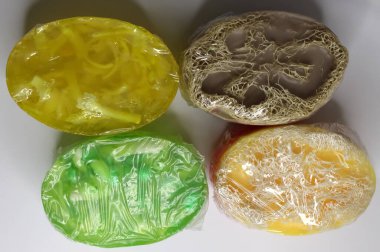 Çeşitli şekillerde dört canlı, jöle gibi nesne şeffaf plastiğe sarılıp eşsiz dokularını ve renklerini sergiliyor..