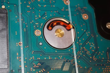 Detaylı bakır izleri olan karmaşık bir elektronik devre kartı ve belirgin bir işleme alanı modern teknolojinin karmaşıklığını gösteriyor..