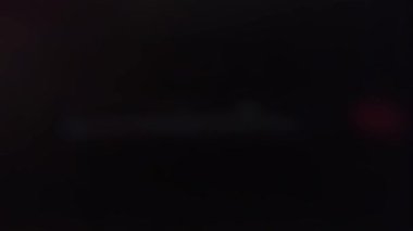 Siyah ekranda titreşimli lazer şeridi. Bulanık parıltı ve enerji kayboluyor. 4K 'da üst üste koymak için stok etkisi.