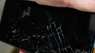 Bir kişi akıllı telefonu kırık bir ekranla inceliyor, hasarı onarmak için çeşitli DIY yöntemlerini araştırıyor. Konferansta, cihazlarını ihtiyaç duymadan restore etmek isteyen kullanıcılar için pratik çözümler üzerinde duruluyor