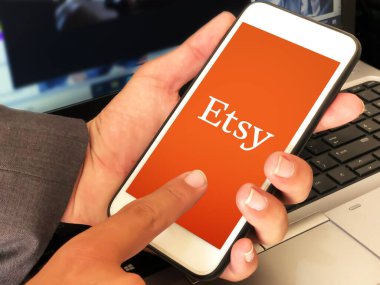 Online Shopping platform etsy editorial background with man using on mobile.