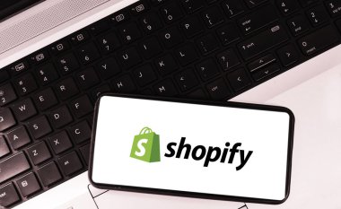 Shopify online shopping platform ecommerce background with laptop and mobile, editorial backdrop