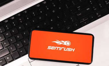 SEO tool on mobile screen background with laptop, semrush editorial backdrop