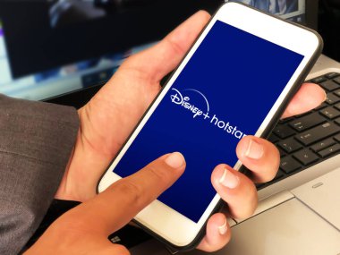 Disney hotstar ott canlı yayın platformu editör arkaplanı ve uygulaması cep telefonunda açıldı. Disney Hot Star kullanan adam