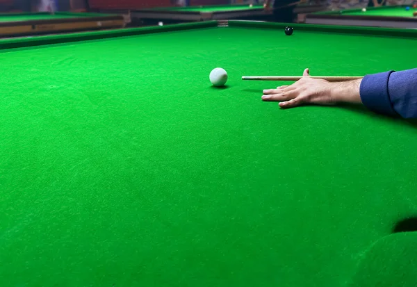 stock image Side view of a man hitting the white ball on a snooker table with selective blur in the backdrop. Snooker background wallpaper.