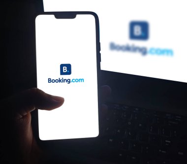 Booking.com mobil uygulamasını kullanarak otel ve uçuş öncesi ön rezervasyon, editoryal arkaplan