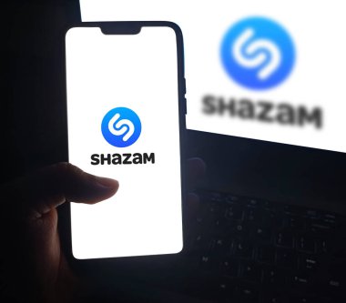 Shazam 'ın Mobil sürümünü kullanan kişi, müziği örnekleme sürümü ile tanımlamak için kullanılan uygulama. Editörel teknik arkaplan