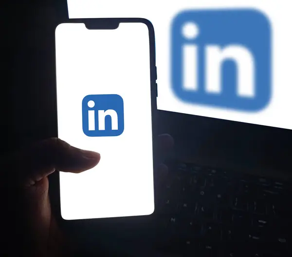 Stock image Person using LinkedIn on smartphone to find out jobs, editorial background