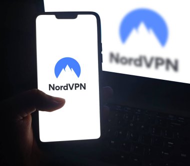 Akıllı telefondaki NordVPN ile gezinen adam, editoryal teknik arkaplan