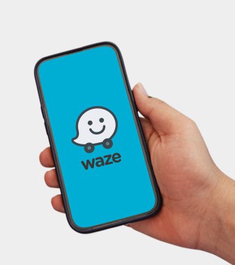 Yolculuk sırasında Waze 'i akıllı telefonda doğru yön için kullanan adam, editoryal arkaplan