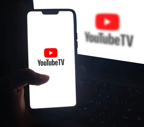 stock image Man watching movies and series on YouTube TV service through smartphone, editorial background