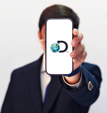 Professional Presentation of Discovery App on Mobile Screen by Man in Suit, with Editorial Background Highlighting App Features and Insights