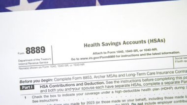 Sağlık Tasarruf Hesapları için 8889 numaralı form. Arkaplanda Amerikan bayrağını kapatıyoruz.