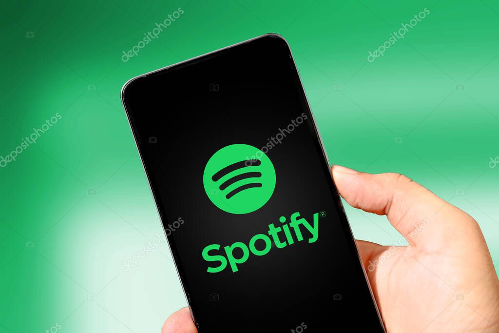 Spotify Music application on mobile screen close up, illustrative editorial. Audio listening mobile app background